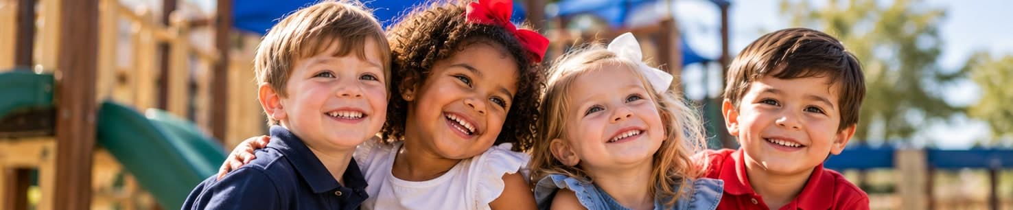 Four smiling preschool children on a playground